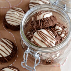 Peppermint Patty Cookies drizzled with chocolate in a glass jar