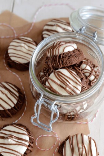 Peppermint Patty Cookies drizzled with chocolate in a glass jar
