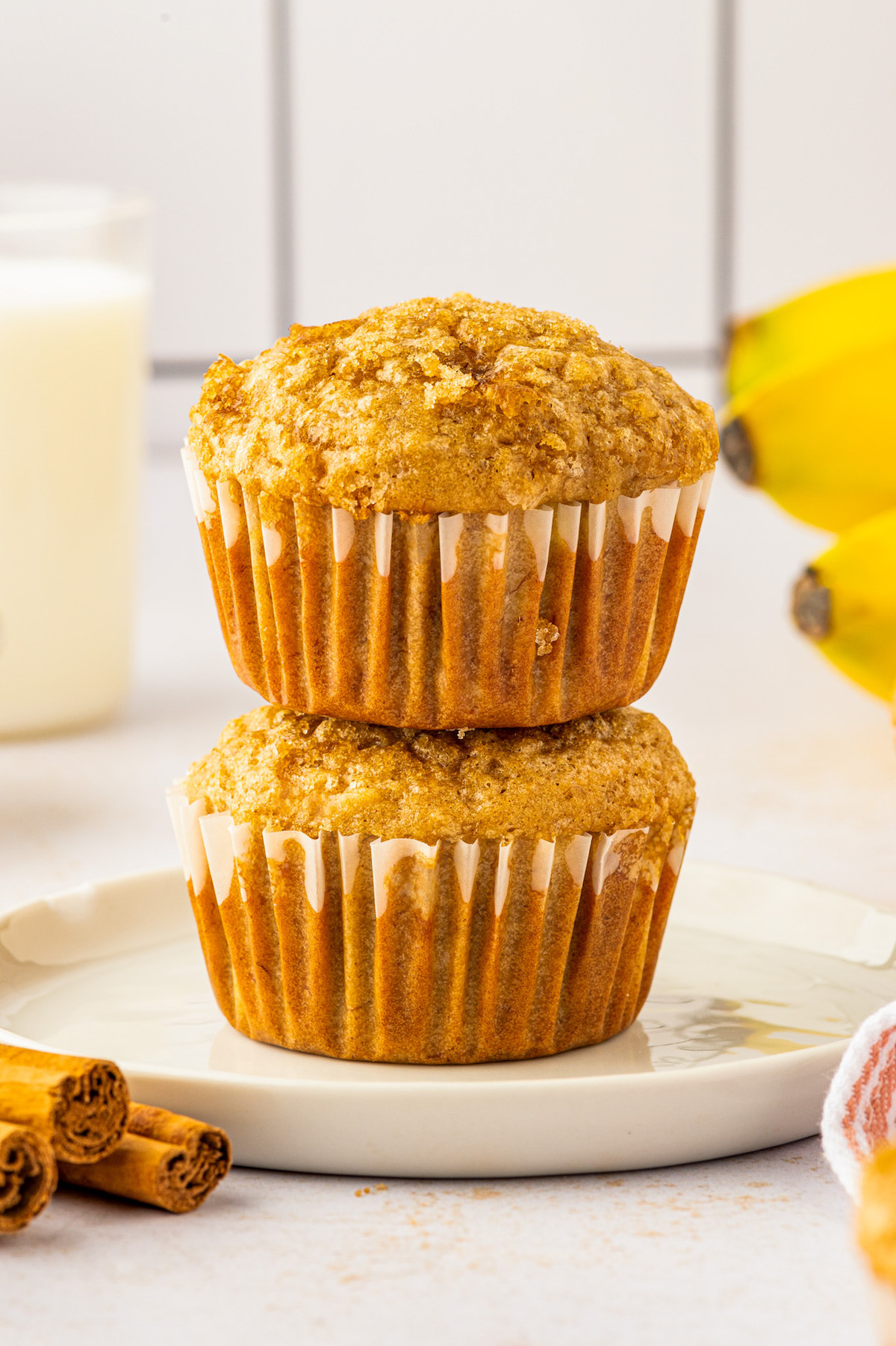 Two stacked brown sugar banana muffins on a plate. 