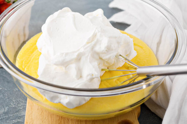 Whipped cream and pudding in a bowl ready to be whisked together.