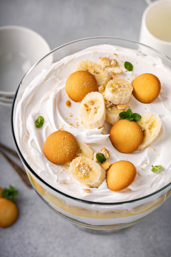 Top view of pudding in a large bowl topped with whipped cream, banana slices and vanilla wafers.