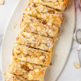 A braided pastry topped with sliced almonds.