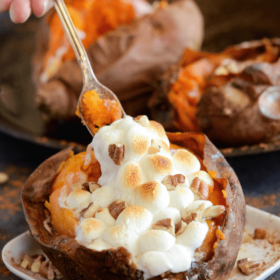 Fully Loaded Sweet Potatoes topped with melty marshmallows being eaten with a fork
