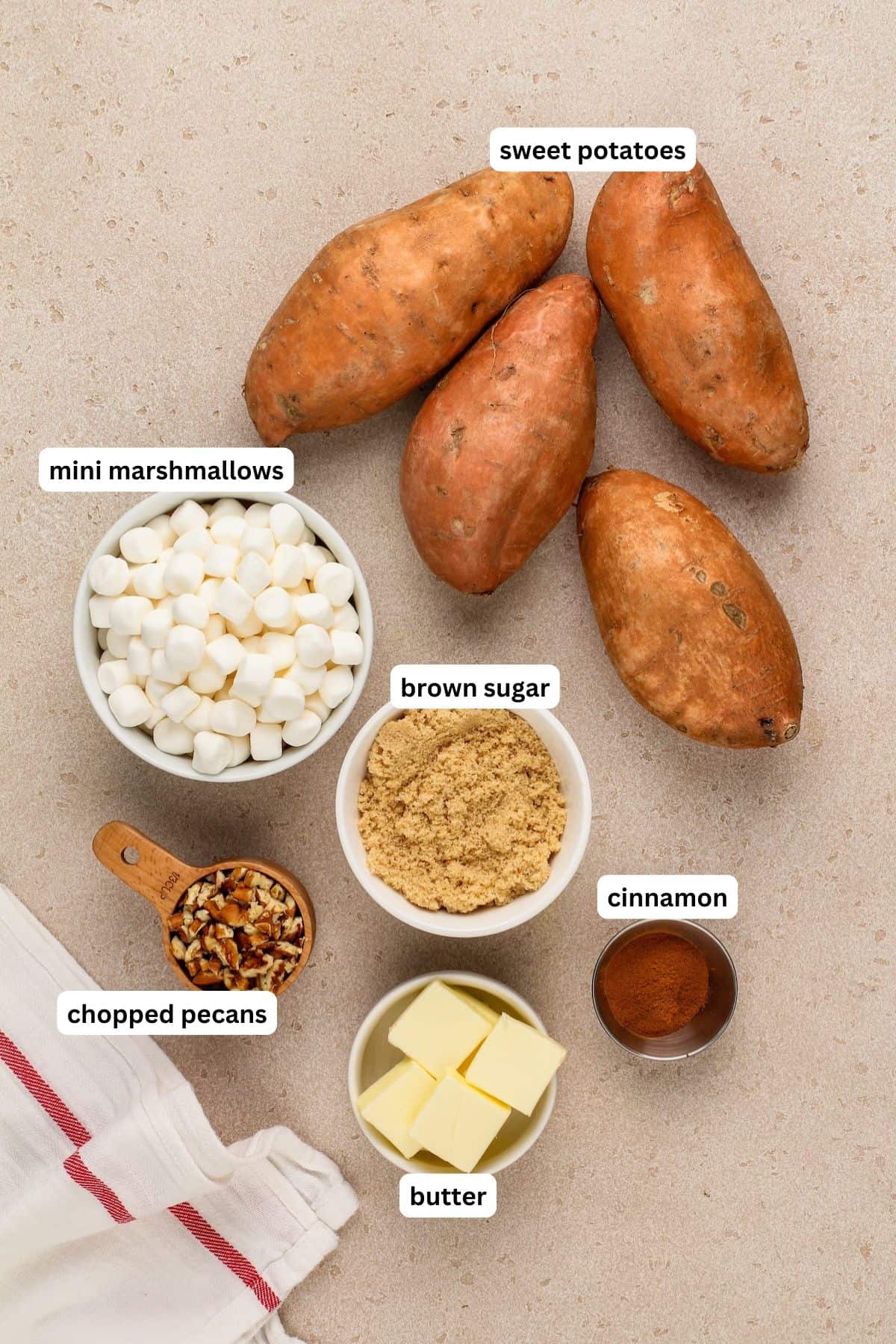 The ingredients for loaded sweet potato recipe in order from top to bottom: sweet potatoes, mini marshmallows, brown sugar, chopped pecans, butter, cinnamon.