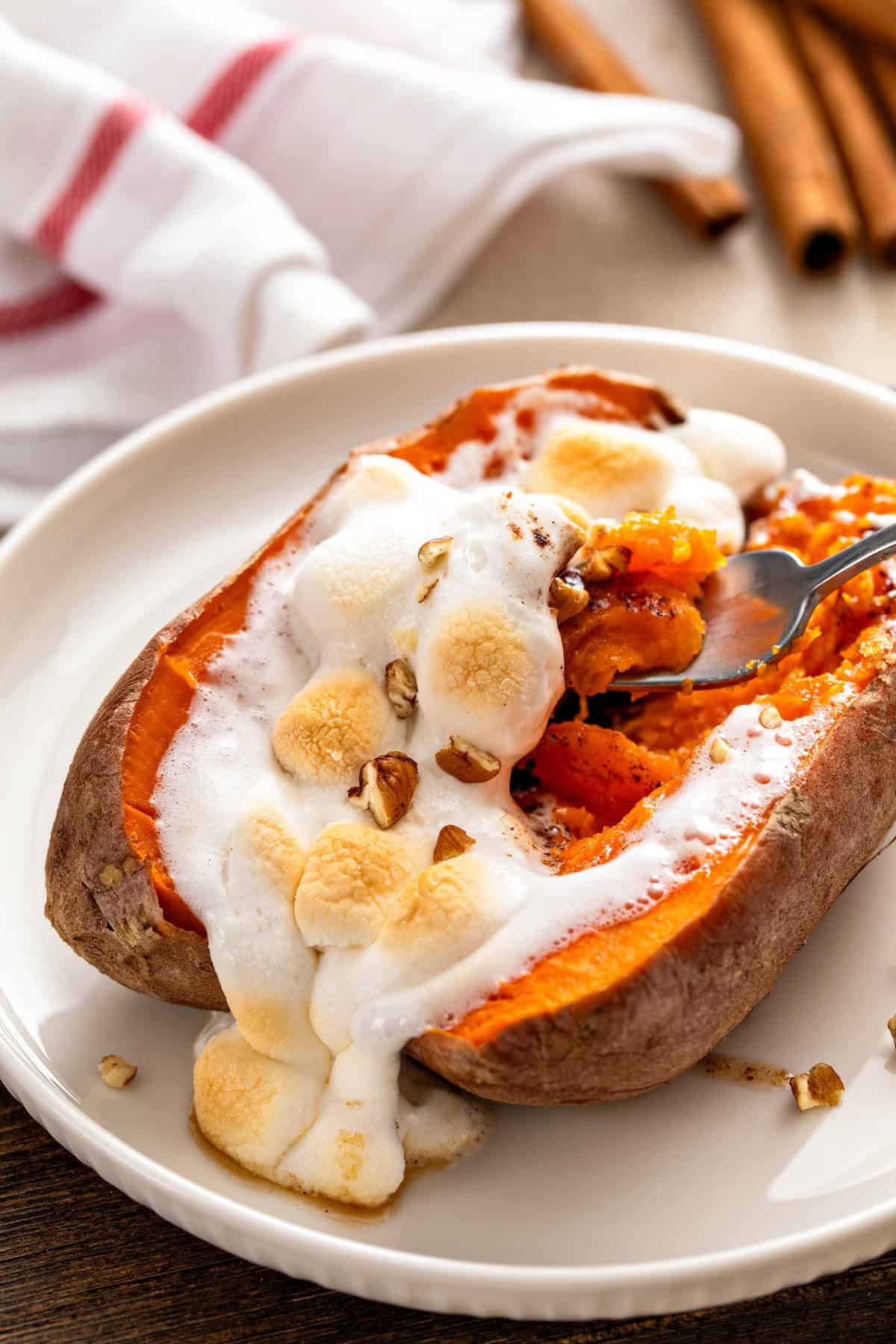 Sweet mini marshmallows are melting out of a loaded sweet potato.