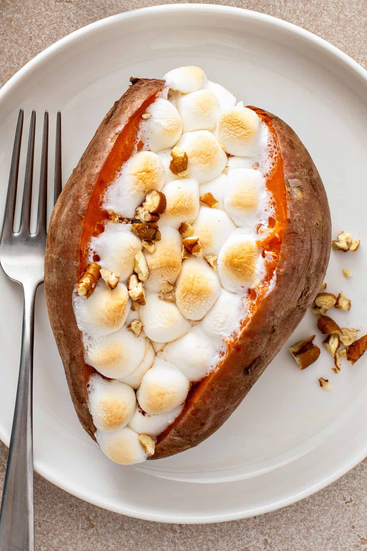 Loaded sweet potato on a plate with a fork.