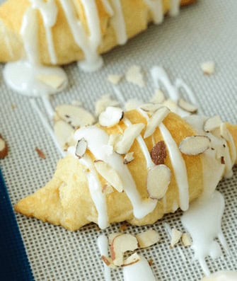 An Almond Stuffed Crescent Roll Topped with Icing and Chopped Almonds