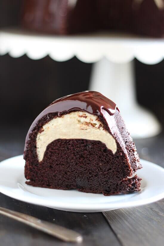A Slice of Cheesecake-Filled Chocolate Bundt Cake on a White Plate