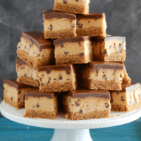 Peanut Butter Cookie Dough Bars stacked on a white cake stand