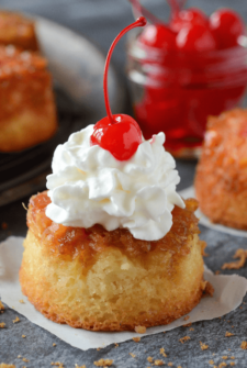 Mini Pineapple Upside Down Cupcakes topped with whipped cream and cherries