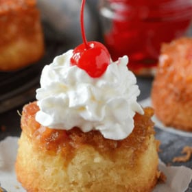 Mini Pineapple Upside Down Cupcakes topped with whipped cream and cherries