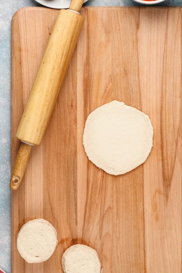 Biscuit dough has been flattened into a four inch round.