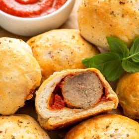A single saucy meatball bomb has been sliced in half to reveal a cooked through center.