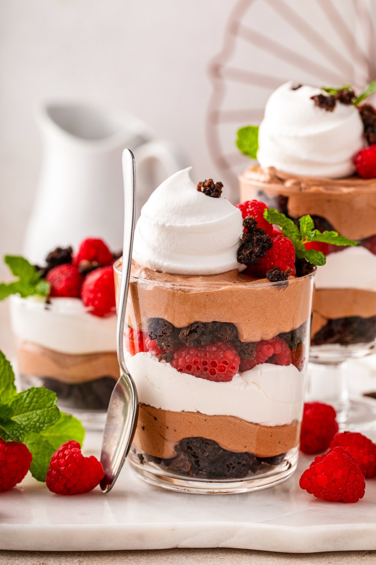 Brownie trifle with layers of chocolate pudding, raspberries and whipped creamy in a trifle bowl.