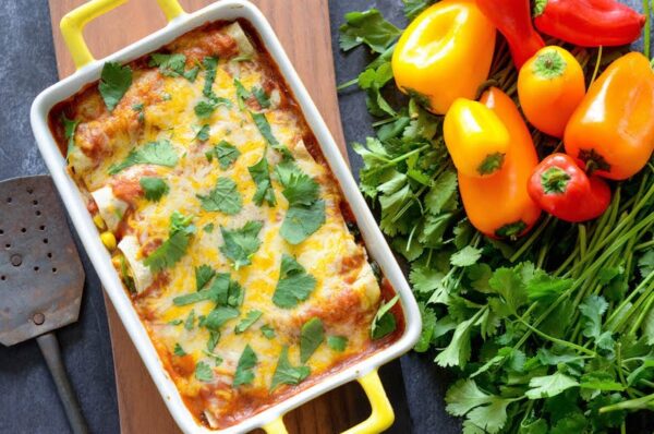 Vegetable Enchiladas in casserole dish topped with fresh cilantro. 