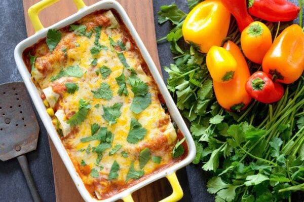 Gemüse-Enchiladas in einer Auflaufform, gekrönt mit frischem Koriander.