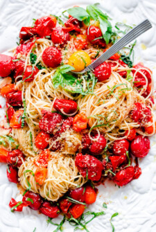 Spaghettini With Roasted Tomatoes, Basil And Crispy Breadcrumbs on a White Platter