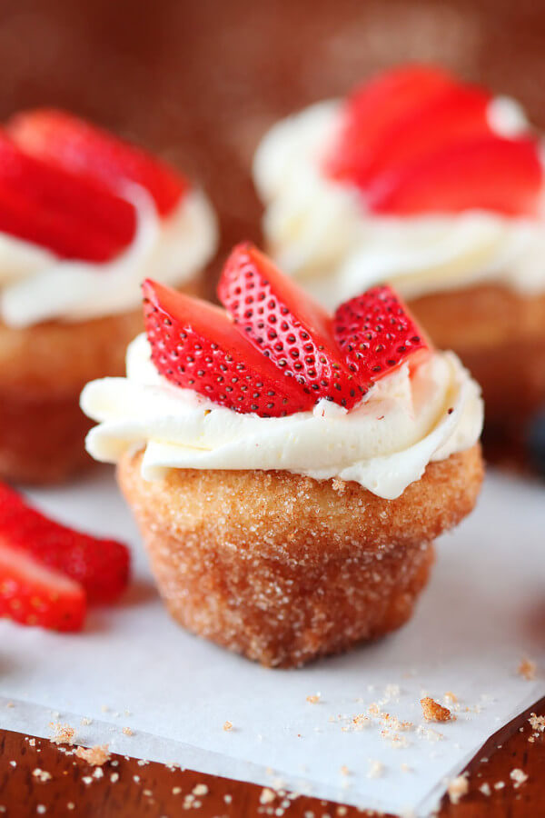 A Strawberry Shortcake Doughnut Muffin Topped with Sliced Strawberries and Frosting