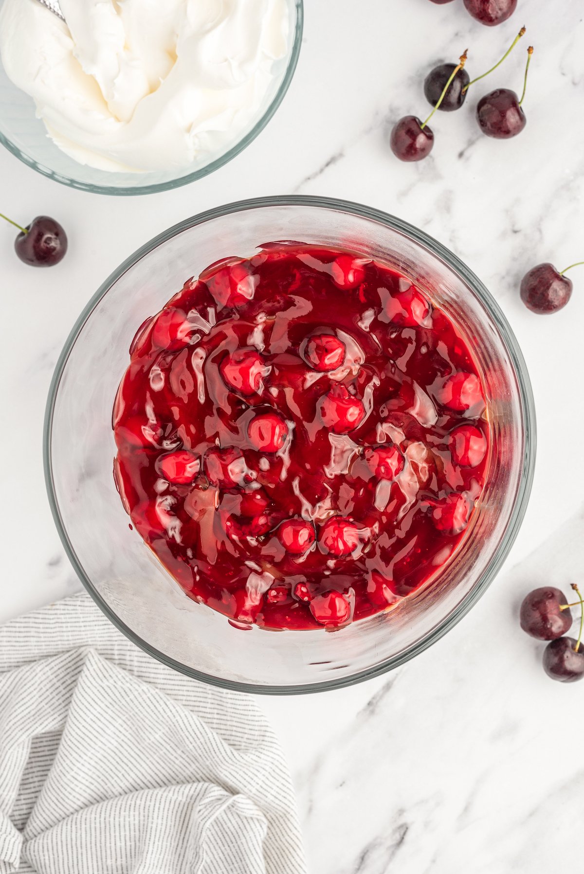 Overhead shot of a layer of cherry pie filling in a dish.