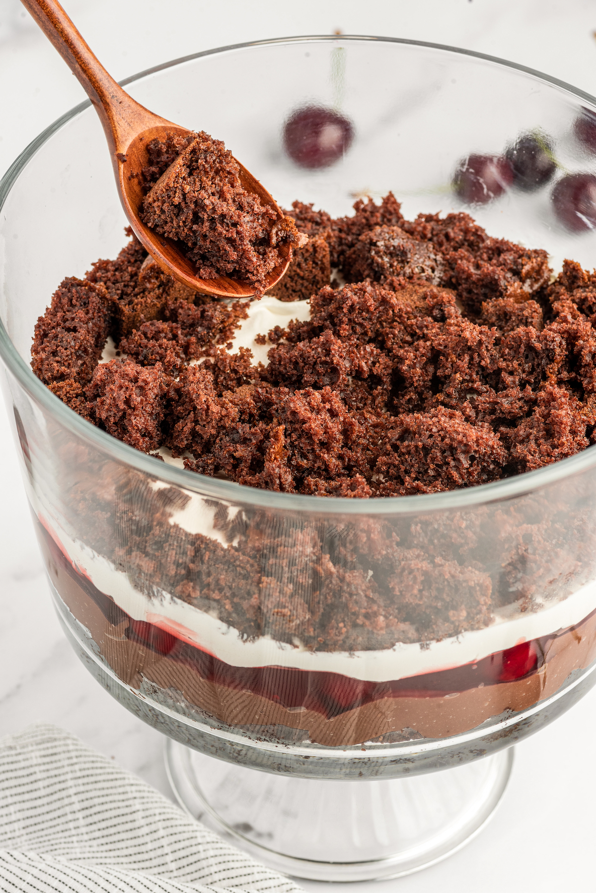 Adding a layer of cake to the glass dish.