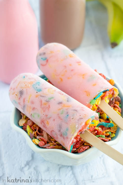 Milk and Cereal Breakfast Popsicles on Top of a Bowl of Fruity Pebbles