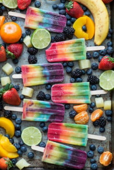 Rainbow Popsicles Surrounded by Various Fruits