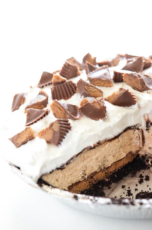 Reese's Peanut Butter No-Bake Pie! It all starts with a chocolate crust and a layer of whole Reese's Cups in the bottom of the pie! Then layers of peanut butter filling, chocolate and whipped cream! It's a fluffy peanut butter & chocolate dream!