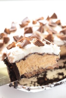 Reese's Peanut Butter No-Bake Pie! It all starts with a chocolate crust and a layer of whole Reese's Cups in the bottom of the pie! Then layers of peanut butter filling, chocolate and whipped cream! It's a fluffy peanut butter & chocolate dream!