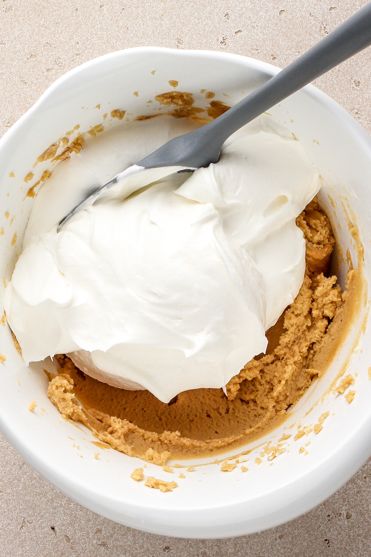 Folding whipped cream into peanut butter filling.