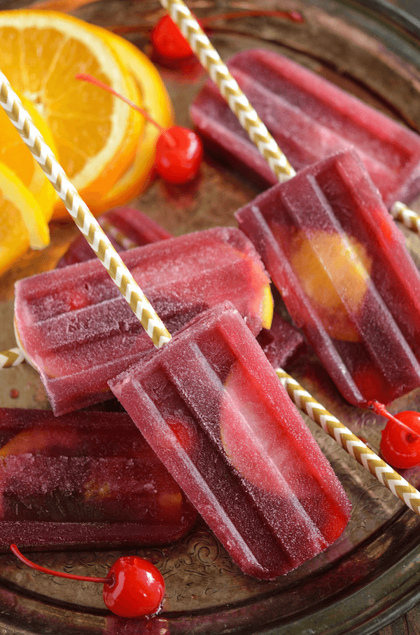 Sangria Popsicles with Orange Slices and Cherries on a Serving Tray