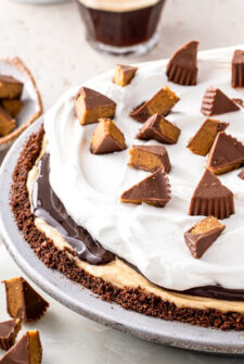 A peanut butter pie topped with hot fudge, whipped cream, and