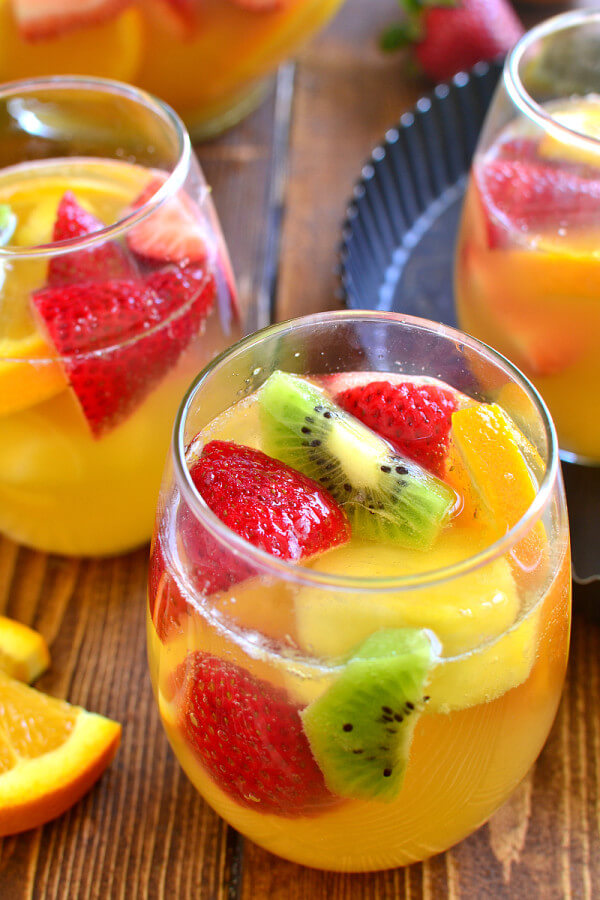 Three Glasses of Tropical Sangria with Slices of Fresh Fruit