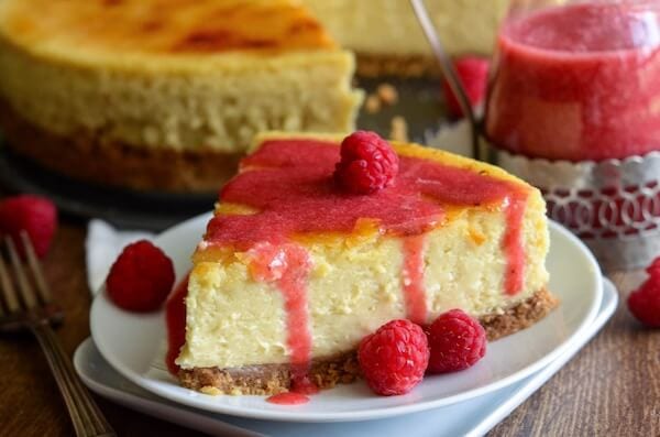 A Close-Up Shot of a Piece of Creme Brulee Cheesecake Covered in Raspberry Sauce