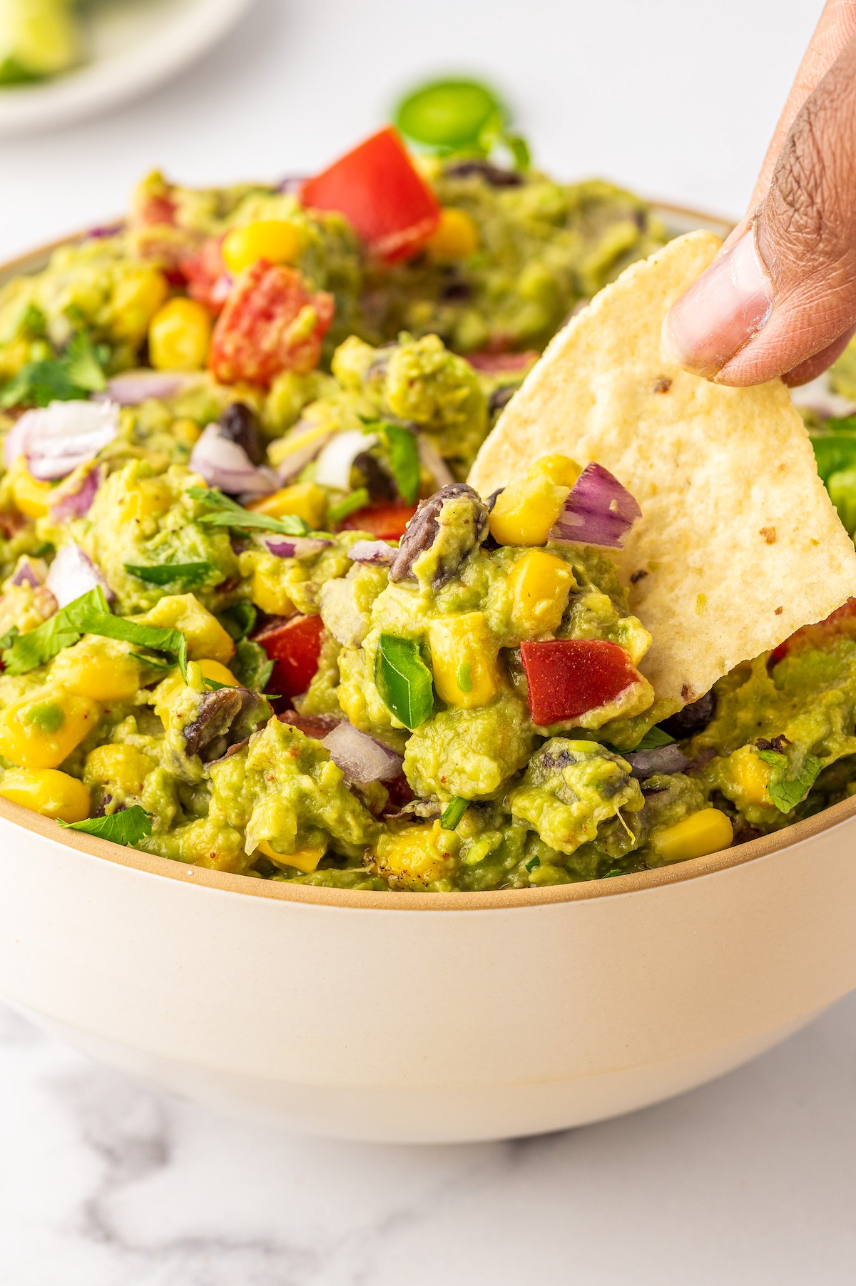 Dipping a corn chip into loaded guacamole. 