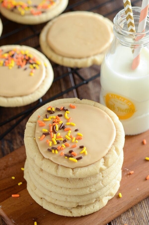 Stacks of soft maple sugar cookies frosted with maple icing and topped with orange and black sprinkles.