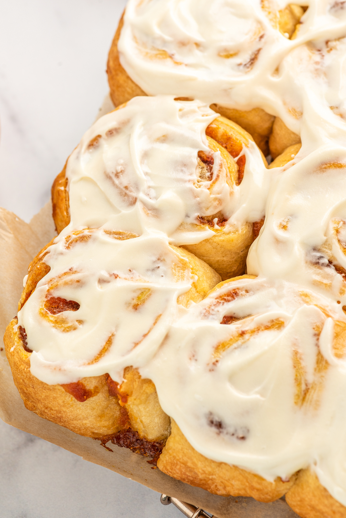 Close-up of frosted pumpkin cinnamon rolls. 