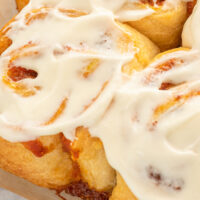 Close-up of frosted pumpkin cinnamon rolls.