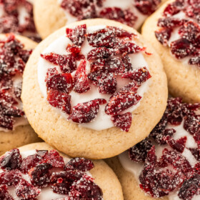 Cranberry cookies with frosting and sugared, dried cranberries on top.