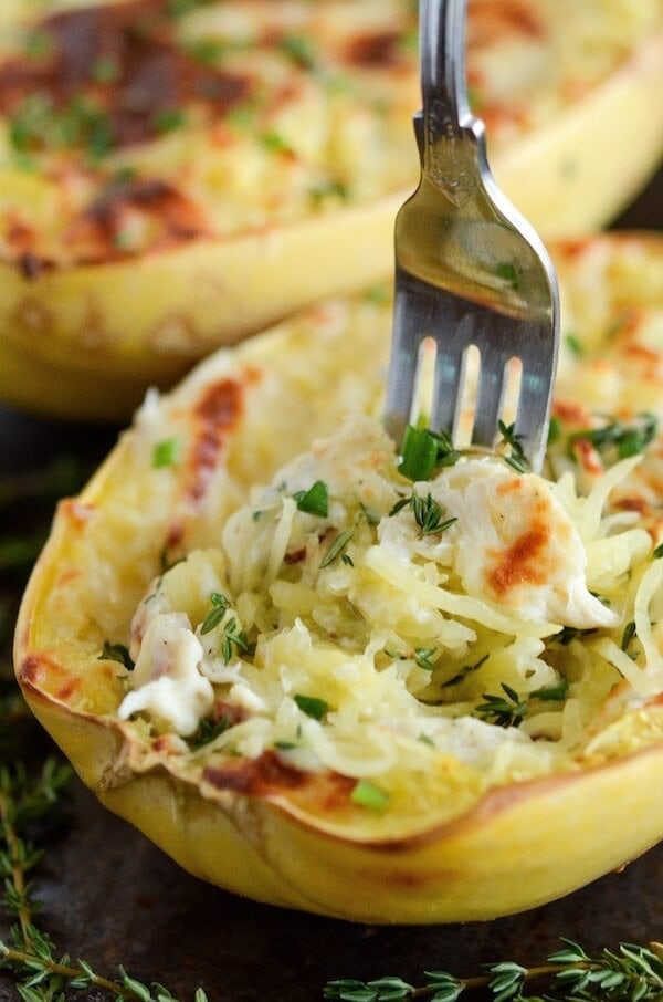 A Four Cheese Chicken Stuffed Spaghetti Squash on a Baking Sheet with a Fork Stuck Into It