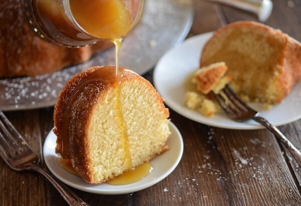 Een stuk amandelpuddingcake met amarettosaus op een wit bord met een vork