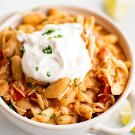 A bowl of taco ranch chicken chili topped with sour cream.