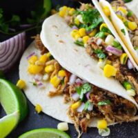 Crispy Pork Carnitas with Corn Salsa - easy pork carnitas are made in a slow cooker or instant pot and then pan fried till crispy. Serve as tacos with fresh corn salsa, with rice and beans or with eggs for breakfast!