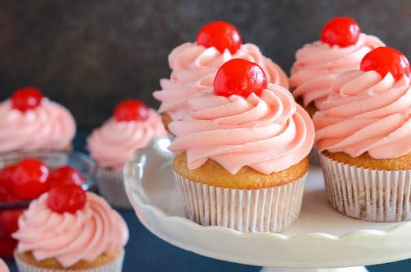 Maraschino Cherry Cupcakes: Sweet almond scented cupcakes are filled with bites of red maraschino cherries and topped with a gorgeous bright maraschino cherry buttercream!