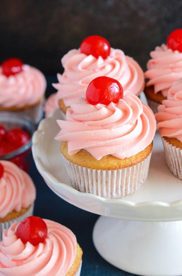 Maraschino Cherry Cupcakes: Sweet almond scented cupcakes are filled with bites of red maraschino cherries and topped with a gorgeous bright maraschino cherry buttercream!