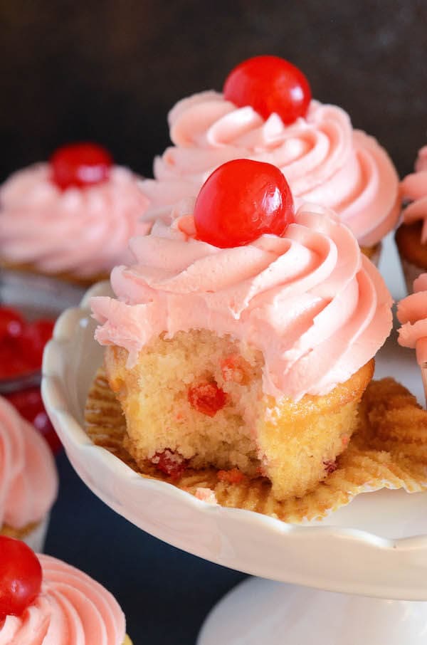 Maraschino Cherry Cupcakes: Sweet almond scented cupcakes are filled with bites of red maraschino cherries and topped with a gorgeous bright maraschino cherry buttercream!