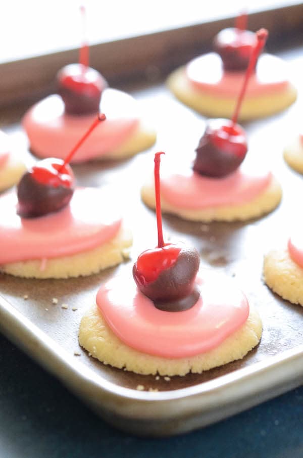 Cherry Cordial Cookies: these intricate looking cookies are surprisingly easy to make. You start with a soft shortbread cookie base, spread them with a creamy cherry cordial icing and top them with a chocolate cherry. 