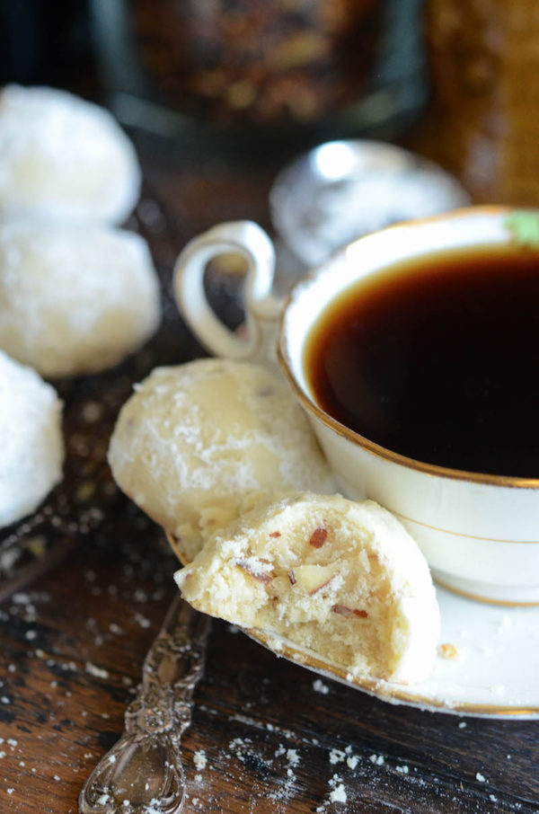 Two Almond Shortbread Cookies on a White Plate With a Full Tea Cup