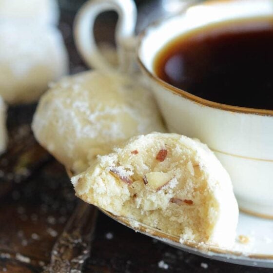 Two Almond Shortbread Cookies Next to a Cup of Black Tea