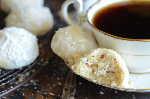 Almond Shortbread Cookies on a Plate with a Gold Rim Beside More Cookies on a Cooling Rack