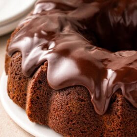 Thick chocolate ganache tops a chocolate milk bundt cake.